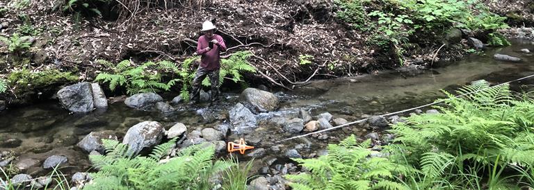 Geologist taking measurements in a stream